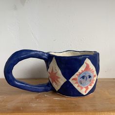 handmade ceramic mug decorated in dark blue and pink paint, an image of a star and sun is visible from this angle. Hand Built Cups, Ceramics Art Ideas, Hand Made Mugs, Mug Pottery Ideas, Glaze Pottery Ideas, Ceramics Ideas Pottery Sculpting, Hand Built Mug, Handmade Ceramic Mug, Ceramics Mug Ideas