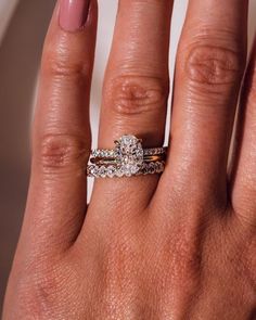 a woman's hand with two wedding rings on her left and the middle finger