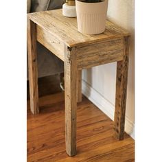 a small wooden table with a potted plant on top