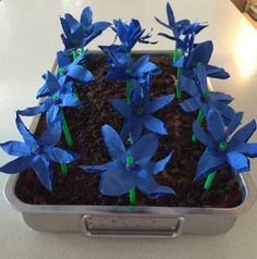 some blue flowers in a metal container on a table