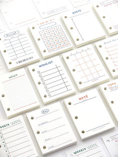 many different types of notepads are arranged on a white surface with gold dots