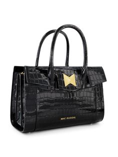 Transform your wardrobe with our Crocodile Leather Tote Bag, embellished with dazzling gold hardware. Crafted from authentic crocodile leather, this tote exudes luxury and offers exceptional durability. Its spacious design and timeless elegance make it the perfect accessory for any occasion. Mac Duggal Crocodile Embossed Leather Construction Croc-embossed and 24k Gold-plated hardware Two exterior pockets/ two interior pockets Chic top handle with 22" in detachable strap for shoulder or crossbody wear Magnet & zipper closure Large size: H 33 in x W 15.5 in x D 22 in 100% Cow Leather: Lining :100% PU Fits up to: iPad, Airpods, Wallet, and Cosmetic bag Available in Black Style #H90034 Maxi Dresses Fall, Black Leather Tote Bag, Oxford Heels, Mac Duggal, Chic Top, Crocodile Leather, Leather Tote Bag, Handbags On Sale, Embossed Leather