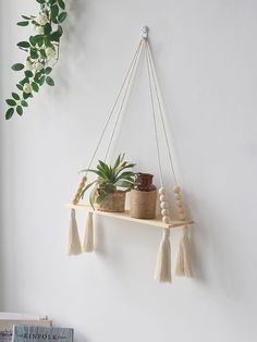 some plants are hanging on a shelf with tassels