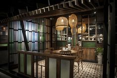 the interior of a restaurant with wooden tables and chairs, lights hanging from the ceiling