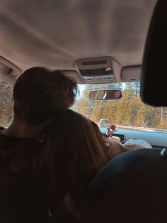 two people sitting in the back seat of a car