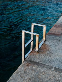 a metal gate sitting on the side of a body of water