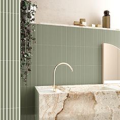 a bathroom with green and white tiles on the wall, sink and mirror in it