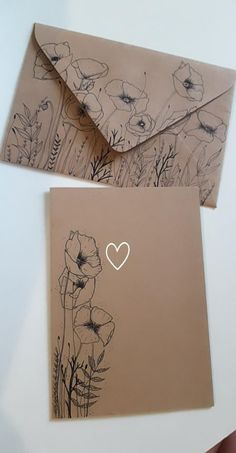 two envelopes with flowers and a heart drawn on them