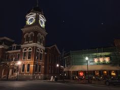 an old building with a clock tower lit up at night