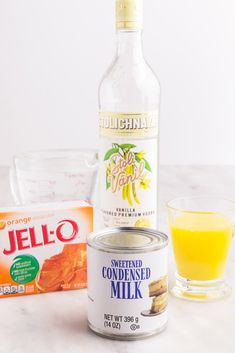 ingredients needed to make an orange smoothie sitting on a counter top next to a bottle of jello