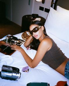 a woman laying on top of a bed next to a camera