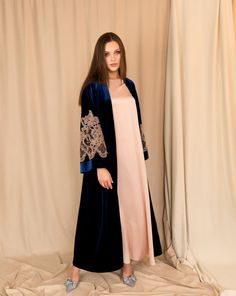 This exquisite abaya exudes sophistication and grace. The rich blue velvet contrasts beautifully with the beige satin of the slip dress, creating a perfect blend of luxury and style. Delicate lace-trimmed sleeves in a matching tone add a subtle, elegant finish to the look.     If you wish to have a blue dress to match blue velvet, please leave a comment as your checkout.  ✓ garment length - 147 cm/58'' ✓ wrap over style ✓ slip dress is included ✓ tie is included Material Composition: Abaya: poly Arabian Abaya, Velvet Abaya, Eid Abaya, Kaftan Abaya, Dubai Abaya, Marine Uniform, Muslim Dress, Abaya Dress, Dress Set