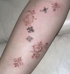 a woman's arm with tattoos on it and flowers in the middle of her arm