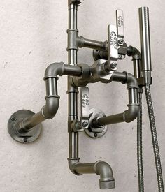 a wall mounted faucet with multiple hoses attached to it's sides