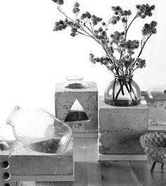 black and white photograph of vases with flowers in them sitting on top of cement blocks