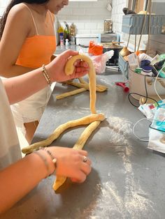 a woman is making some kind of snake shaped bread with her hands on the counter