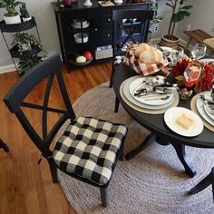 a dining room table set for four with plates and silverware on the placemats