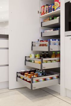 an organized pantry in the corner of a kitchen with lots of food on shelves and drawers