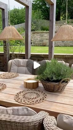 a wooden table topped with lots of wicker chairs and tables covered in plants on top of it