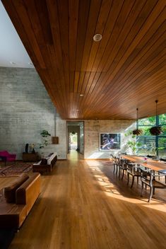 a large open living room with wooden floors and ceiling beams, along with modern furniture