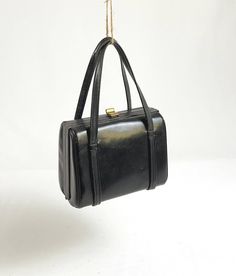 Cute black vintage leather frame handbag from the 40s-50s. Petite, but roomy enough for cell phone, wallet, keys etc.  Approx 7.25 inches wide by 6 inches tall, with a 3.25-inch, 5 inch drop. Black leather outer including strqps with fabric-lined interior and brass hardware and accents, including "feet" on bottom of bag. Made by Elite Handbags, USA. A lovely mid-century classic style purse that does show some age appropriate blemishes, but it has very nice lines and good bones! Could be spiffed Vintage Black Square Shoulder Bag, Vintage Black Box Bag For Everyday, Vintage Evening Box Bag With Detachable Handle, Vintage Black Box Bag For Daily Use, Vintage Box Bag With Detachable Handle For Evening, Vintage Box Bag With Detachable Handle, Black Rectangular Bag For Vintage Fashion, Vintage Square Bags For Formal Occasions, Vintage Square Formal Bags