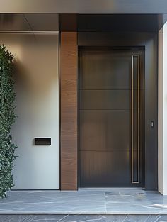 an entrance to a building with a door and some plants on the side walk next to it