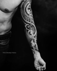 a man's arm with tattoos on it and his hand holding the other arm