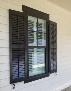 two black shutters on the side of a white house