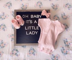 a sign that says oh baby it's a little lady next to some shoes