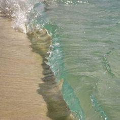 an ocean wave rolls in to the shore