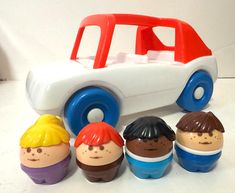 an assortment of toys including a toy car and five children's heads, all in different colors