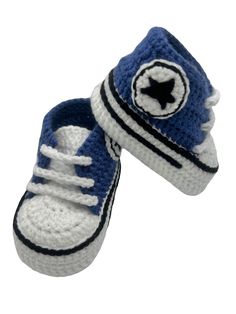 a pair of crocheted blue and white baby shoes