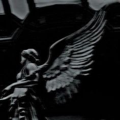 a black and white photo of an angel statue