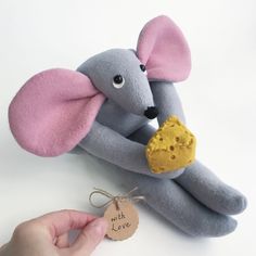 a stuffed mouse holding a cookie in its hand