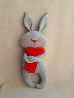 a stuffed animal with a red scarf around it's neck on a white surface