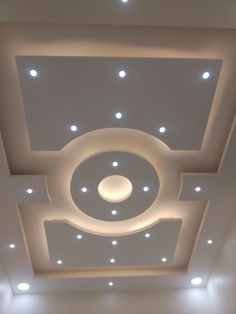 the ceiling is decorated with white lights and circular shapes on it's sides, along with recessed lighting