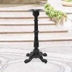 an old fashioned black candle holder stands in front of some steps