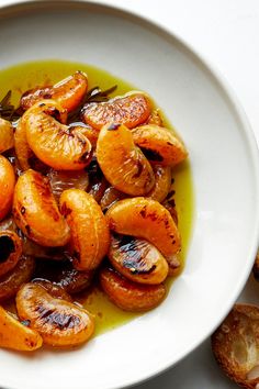 a white plate topped with sliced oranges and olive oil on top of bread slices