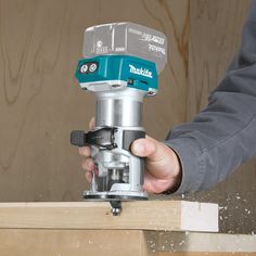 a person using a cordless driller to cut wood planks with a router