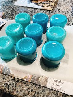 several blue jars sitting on top of a counter next to a paper with the word popular react