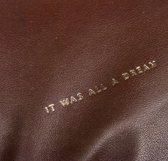 it was all a dream written on the back of a brown leather bag with gold lettering