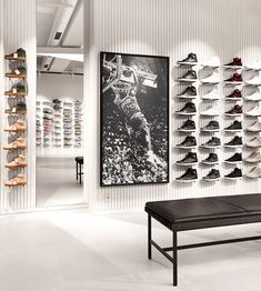 a room filled with lots of shoes next to a wall mounted shoe rack on the wall