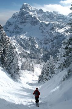 a man riding skis down a snow covered slope