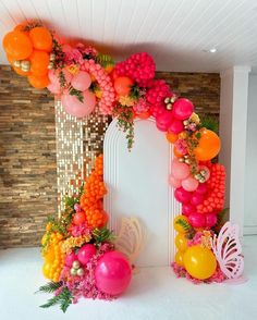 an archway decorated with balloons and flowers