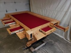 the table is made out of wood and has red felt in it's drawer