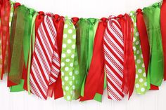 a green and red garland hanging on a wall with polka dots, candy canes and ribbons