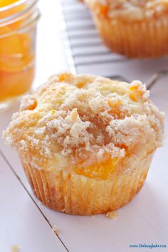 a muffin with powdered sugar on top sitting next to a jar of jelly