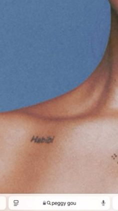 the back of a man's chest with his name tattooed on it, in front of a blue background