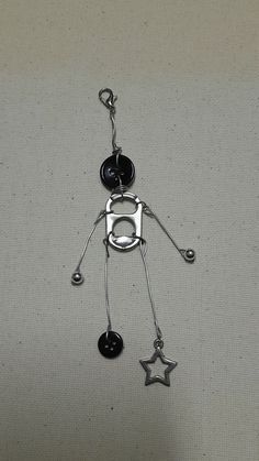 a metal figure with black and white beads hanging from it's side on a gray surface