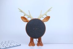 a speaker with antlers on its head next to a computer keyboard and mouse pad